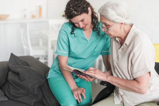 nurse-looking-senior-woman-reading-book